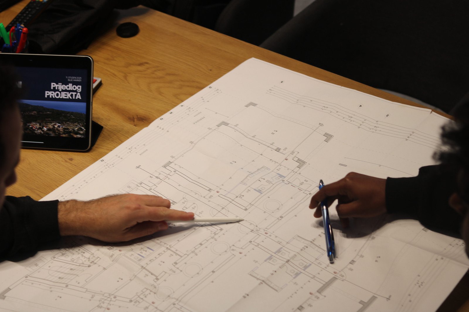 Dvoje ljudi pregledava arhitektonske planove